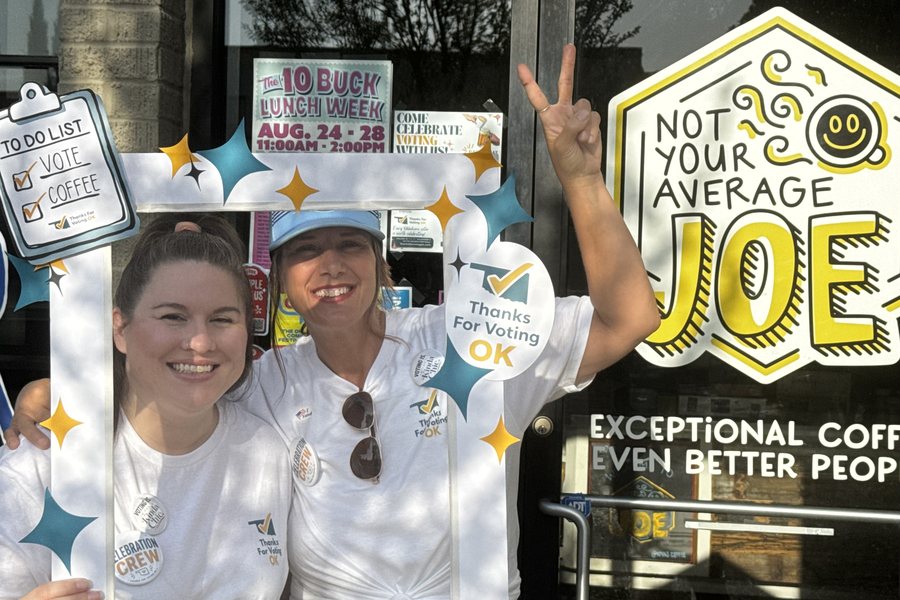 Two Thanks For Voting OK Celebration Crew members holding a photo frame prop outside Not Your Average Joe in Oklahoma City
